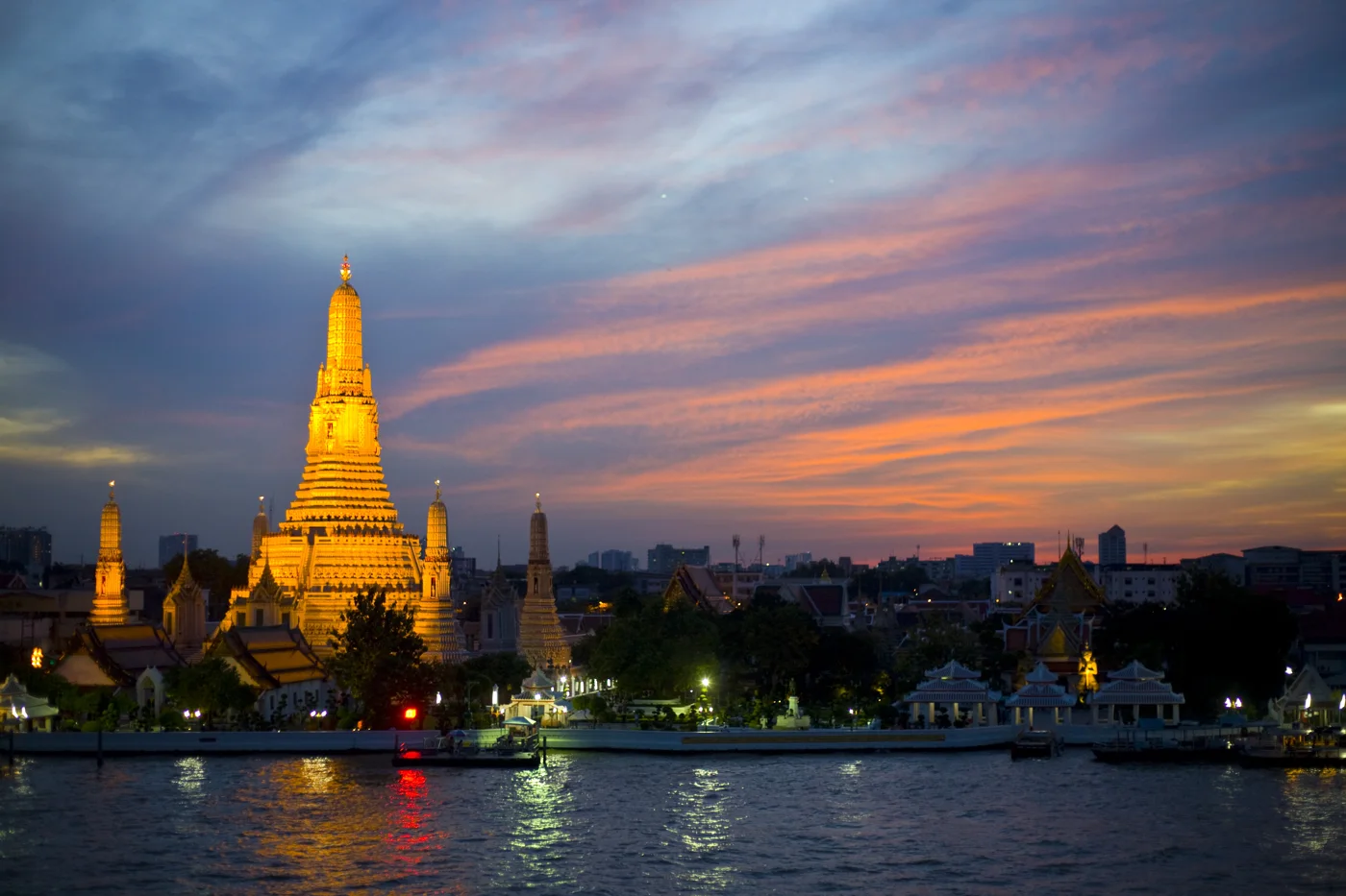 Wat Arun glowing against Bangkok’s sunset sky