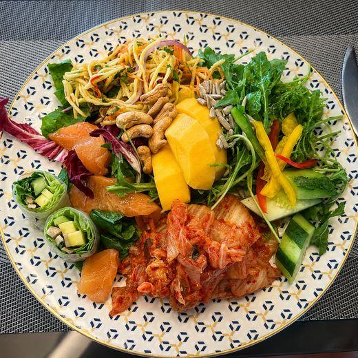 A plate built from the Club Lounge buffet on the 24th floor: smoked salmon, green mango salad, kimchi, fresh rice paper rolls and mango.